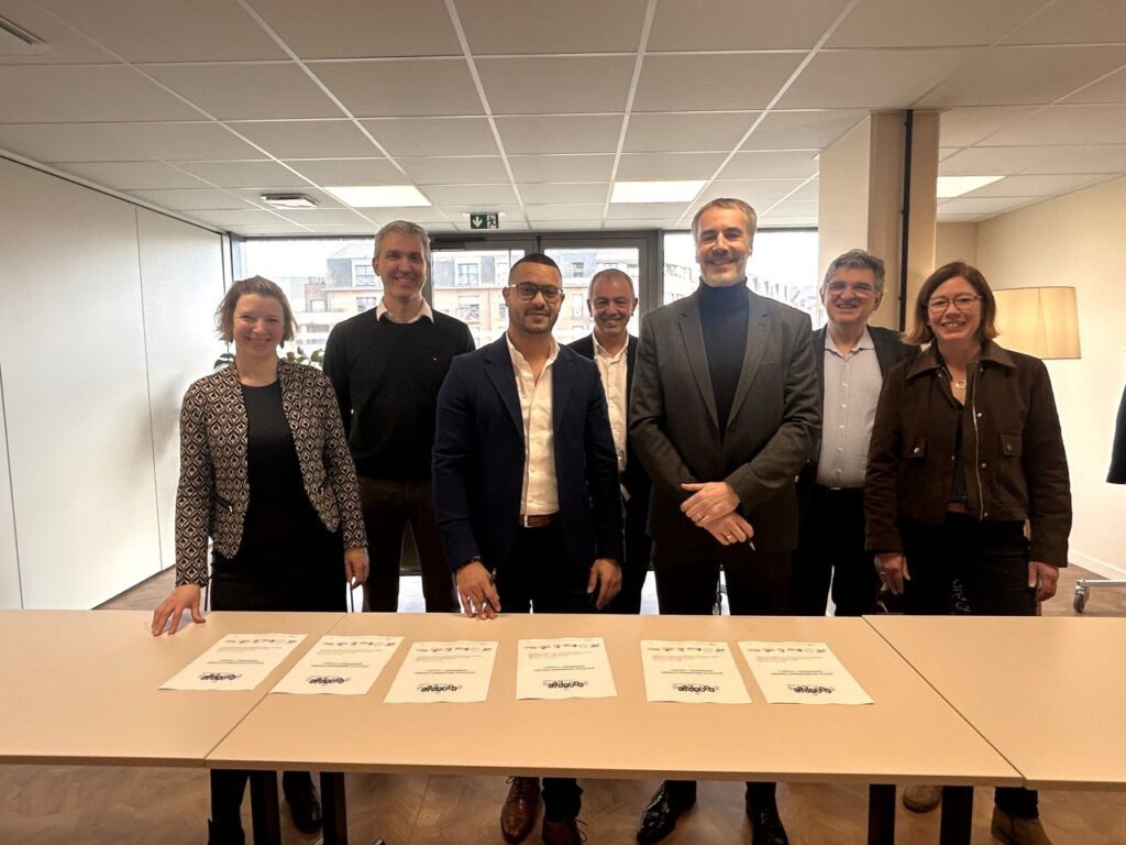 Un groupe de personne représentant le Réseau Canopée, dont le Directeur général de Partenord le Groupe Eric Cojon. Ils sont debouts dans une pièce devant une table.